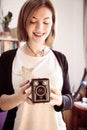 Beautiful laughing girl with a vintage film camera