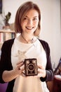 Beautiful laughing girl with a vintage film camera