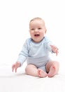 Beautiful laughing happy baby boy sitting on bed