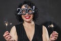 Beautiful laughing plus size girl in evening dress with sparklers. Bright brunette with a festive mood. Black background. Close-up Royalty Free Stock Photo