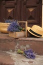 Beautiful lavender flowers and straw hat near building Royalty Free Stock Photo