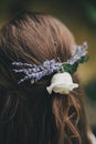 Beautiful lavender and rose flowers in bride hair close up. Stylish bride hairstyle with lavender flowers for provence wedding.