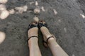 Beautiful legs of a girl in black sandals and toes with a pedicure. Closeup of feet with painted nails in black sandals. Royalty Free Stock Photo