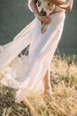 Beautiful legs girl in a white winding in the wind dress, with grass in hand, the horns of the deer from below, close-up, nature,