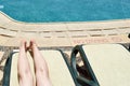 Beautiful legs, girls feet, women on the background of a deckchair and pool on a tropical warm exotic seaside resort, summer Royalty Free Stock Photo