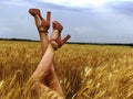 Beautiful legs with high heels, young stylish girl agrarian in a wheat field
