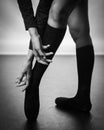 Legs of young ballerina with pointe shoes dancing on a black floor background. Ballet practice. Feet of ballet dancer.