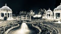 Beautiful leisure park with gazebos and wooden bridge over water with night lighting. North Cyprus monochrome landscape Royalty Free Stock Photo