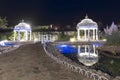 Beautiful leisure park with two gazebos and wooden bridge over water with night lighting. North Cyprus landscape Royalty Free Stock Photo