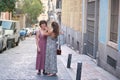 Beautiful lesbian couple wearing long dresses, combing each other hair in the street