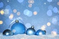 Beautiful light blue Christmas balls on snow against blurred festive lights, bokeh effect. Space for text Royalty Free Stock Photo