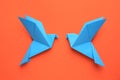 Beautiful light blue origami birds on orange background, flat lay Royalty Free Stock Photo