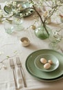 Beautiful light green and beige colors morning table decoration lace tablecloth and napkins, spring cherry blossom branch, silver