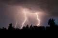 beautiful lightning during a thunderstorm at night in a forest that caused a fire, against a dark sky with rain Royalty Free Stock Photo