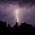 beautiful lightning during a thunderstorm at night in a forest that caused a fire, against a dark sky with rain Royalty Free Stock Photo