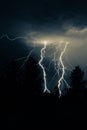 beautiful lightning during a thunderstorm at night in a forest that caused a fire, against a dark sky with rain Royalty Free Stock Photo