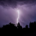 beautiful lightning during a thunderstorm at night in a forest that caused a fire, against a dark sky with rain Royalty Free Stock Photo