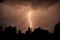 beautiful lightning during a thunderstorm at night in a forest that caused a fire, against a dark sky with rain Royalty Free Stock Photo