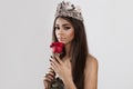 Beautiful like a flower. Woman holding a red rose looking at you the camera isolated white background. Brunette dark hair and skin Royalty Free Stock Photo