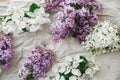 Beautiful lilac flowers, apple blossom and petals on linen fabric flat lay. Spring floral still life on rustic background. Happy Royalty Free Stock Photo