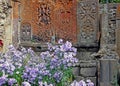 Beautiful lilac flowers on the background of ancient stone crosses