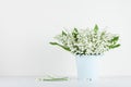 Beautiful lily of the valley flowers in blue vase on white background. Spring aroma bouquet. Royalty Free Stock Photo