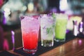 Beautiful line of different colored alcohol cocktails with smoke on a Christmas party, tequila, martini, vodka, and others on part Royalty Free Stock Photo