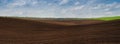 lines and hills of agrarian landscape plowed field, black soil ready for sowing