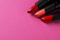 Beautiful lipsticks on pink background, above view. Space for text