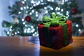 Beautiful lit gift box with christmas tree in the background