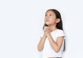 Beautiful little asian child girl praying isolated over white background with looking up. Spirituality and religion concept