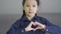 Beautiful little asian girl making a heart shape hand gesture Royalty Free Stock Photo