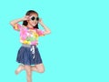 Beautiful little Asian kid girl wearing a flowers summer dress and sunglasses  on cyan background with copy space. Summer Royalty Free Stock Photo