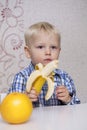 Beautiful little baby boy eats banana Royalty Free Stock Photo