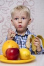 Beautiful little baby boy eats banana Royalty Free Stock Photo