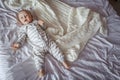 Beautiful little baby boy lying on a white sheet on the bed Royalty Free Stock Photo