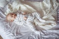 Beautiful little baby boy lying on a white sheet on the bed Royalty Free Stock Photo