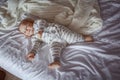 Beautiful little baby boy lying on a white sheet on the bed Royalty Free Stock Photo