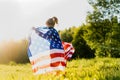 beautiful little blonde girl with the American flag in nature in the sunlight Royalty Free Stock Photo
