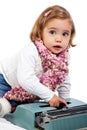 Beautiful little blonde girl playing with a typewriter Royalty Free Stock Photo