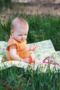 Beautiful little blonde girl sitting on a meadow Royalty Free Stock Photo