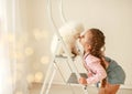 Beautiful little blonde hair girl, has fun smile face, embraces and plays with puppy dog Japanese Spitz. Child and Royalty Free Stock Photo