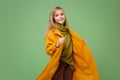 Beautiful little blonde kid girl 12-13 years old in yellow coat posing isolated on pastel green background children Royalty Free Stock Photo