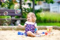 Beautiful little blonde toddler girl having fun with blowing soap bubble blower. Cute adorable baby child playing on Royalty Free Stock Photo