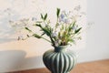 Beautiful little blue flowers in vase in warm sunlight on rustic wooden background. Delicate myosotis petals, forget me not spring Royalty Free Stock Photo