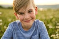 Beautiful little boy in daisy field on sunset, summertime Royalty Free Stock Photo