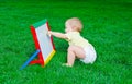 ÃÂ beautiful little boy draws sitting on a lawn