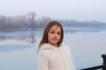 Beautiful little brown-eyed girl in white coat looking at camera seriously