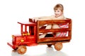 The girl is sitting on a large toy wooden car. Royalty Free Stock Photo