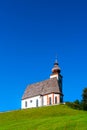 Beautiful little church in Alps. Sunny day, green grass on the h Royalty Free Stock Photo